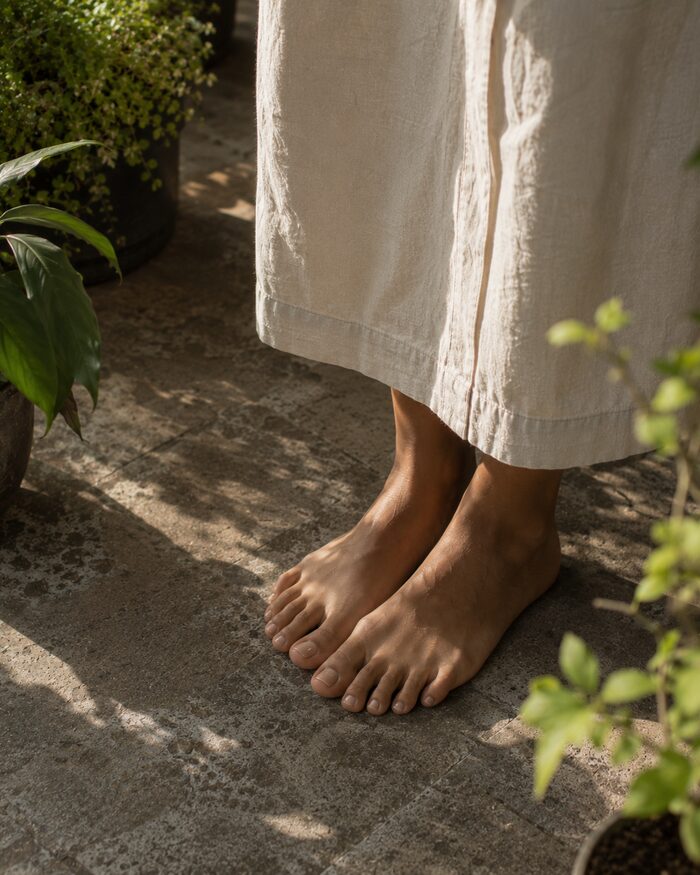 Bare feet grounding on a stone garden path representing natural alignment